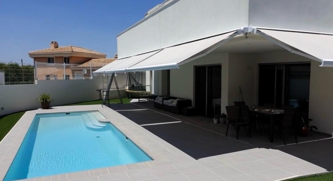 Toldo instalado junto a una piscina en una vivienda
